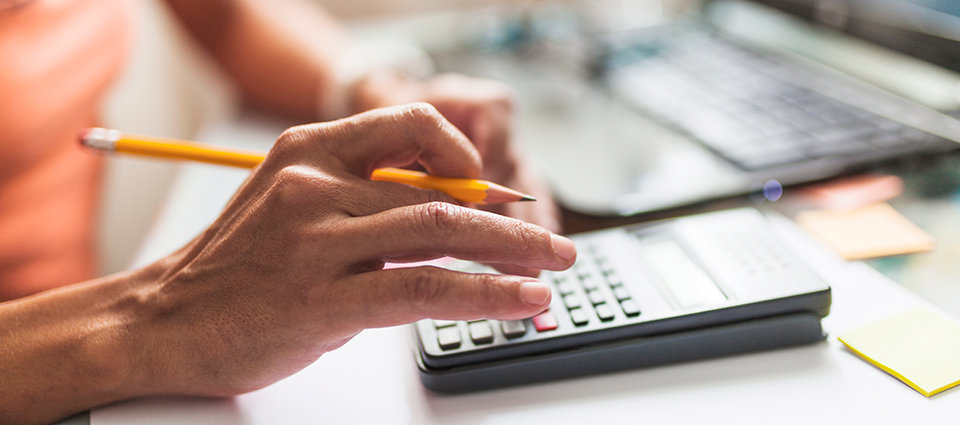 a hand with pencil on a calculator - ROI