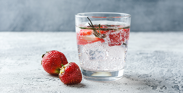 a glass of seltzer with strawberries