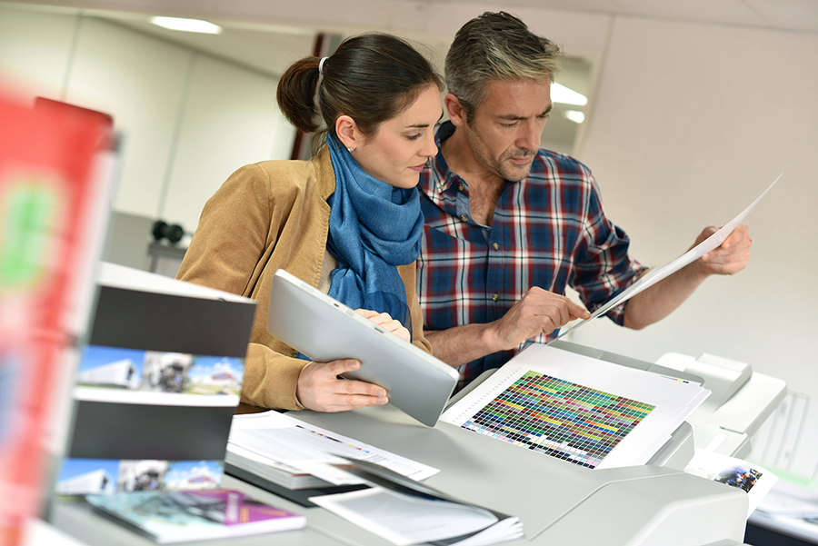 Man and a woman looking at printed advertising